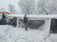 On déblaie la neige du toit pour limiter les dégâts.